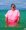 Eine Person in einem pinken T-Shirt steht im Meer und schaut überrascht oder freudig.