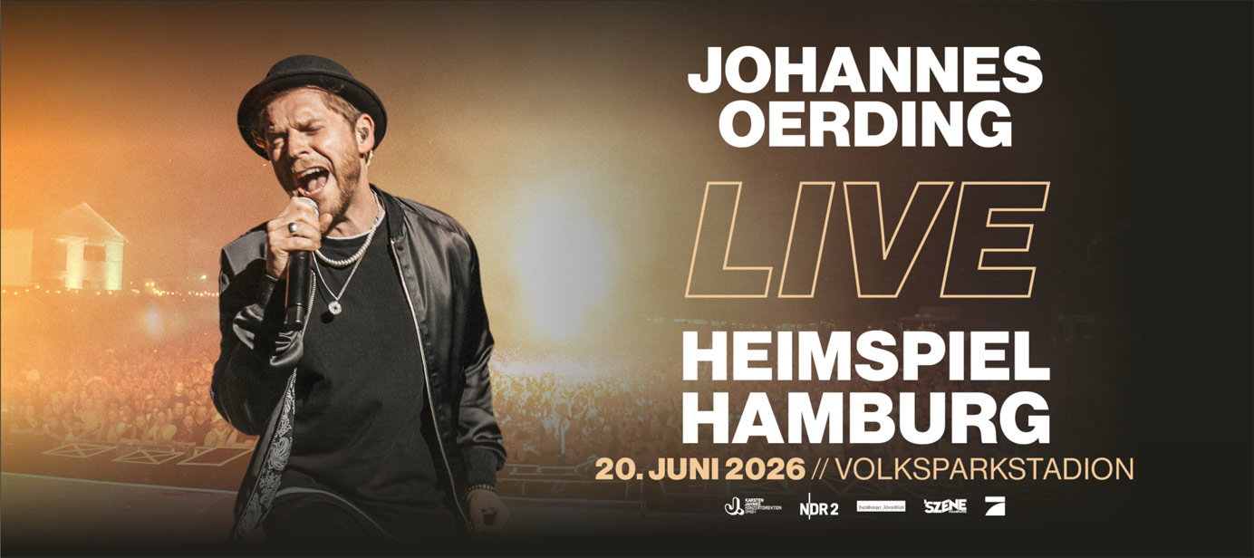 Johannes Oerding mit schwarzem Hut und dunklem Mantel vor grauer Wand. Headerbild für das Konzert Heimspiel Hamburg 2026 im Volksparkstadion.
