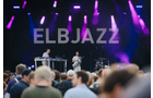 Download Foto: Konzertbühne mit lila Lichtern, 'ELBJAZZ' im Hintergrund; Musiker und Zuschauer im Vordergrund.
