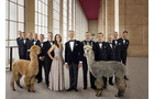 Download Foto: Eine Gruppe elegant gekleideter Menschen steht in einem Saal neben zwei Alpakas.