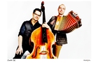 Download Foto: Zwei Männer, einer mit Kontrabass, der andere mit Akkordeon, posieren lächelnd vor einem weißen Hintergrund.