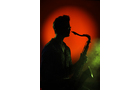 Download Foto: Scherenschnitt eines Saxophonspielers vor rotem Hintergrund, umgeben von grünlichem Nebel.