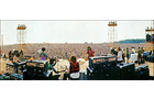 Download Foto: Blick von hinten auf eine Band, die vor einem riesigen Publikum auf einer Open-Air-Bühne spielt. Zahlreiche Zuschauer im Hintergrund.
