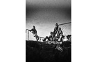 Download Foto: Schwarz-weiß-Foto von fünf Personen auf einem Hügel oder Abhang, die zum Horizont schauen. Eine Person steht, vier sitzen.