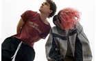Download Foto: Zwei Personen stehen nebeneinander, eine mit rosa Haaren und Kapuzenpullover, die andere in einem roten T-Shirt.
