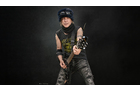 Download Foto: Ein Musiker in dunkler Kleidung spielt eine E-Gitarre vor einem schwarzen Hintergrund.