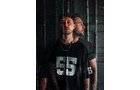 Download Foto: Ein Mann im schwarzen T-Shirt mit der Zahl 55 steht vor einem dunklen, reflektierenden Hintergrund und wirkt halb transparent.