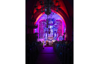 Download Foto: Beleuchteter Kircheninnenraum mit intensiv pinkem und violettem Licht, sichtbarem Altar und geschmücktem Gewölbe.
