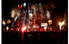 Download Foto: Bühne bei einem Konzert mit Feuerwerk und Lichteffekten, Publikum im Vordergrund.